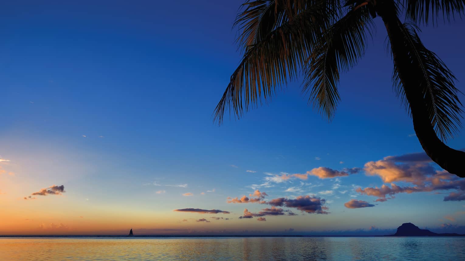 The sun sets over the crystal waters of Thailand, Koh Tao and Koh Nang Yuan silhouetted in the background