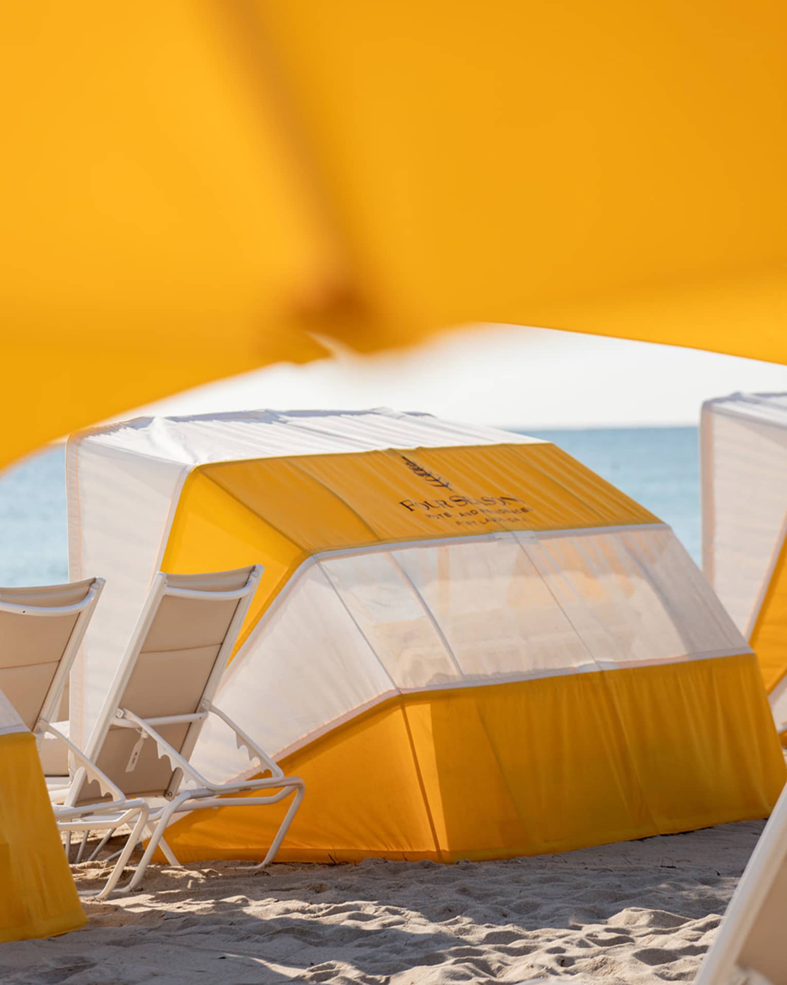 A daybed on the beach with lounge chairs