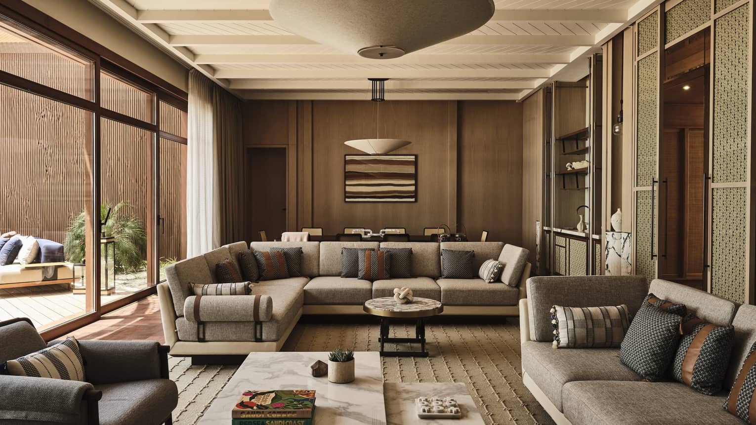 Contemporary living room of a suite at a luxury resort, featuring two sofas and marble coffee tables