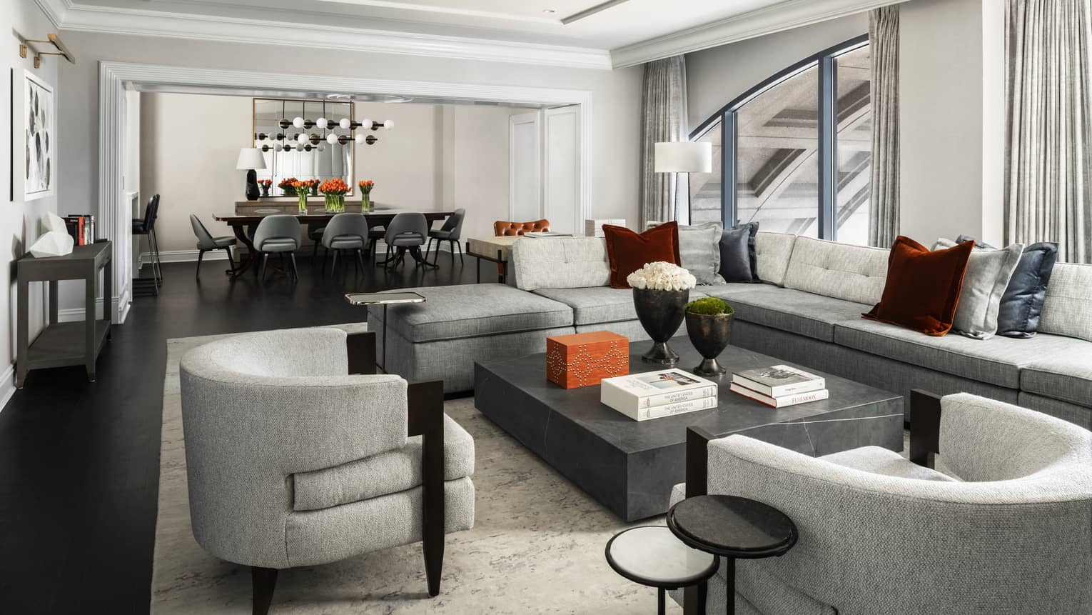Presidential Suite large seating area with modern grey furniture, dining table
