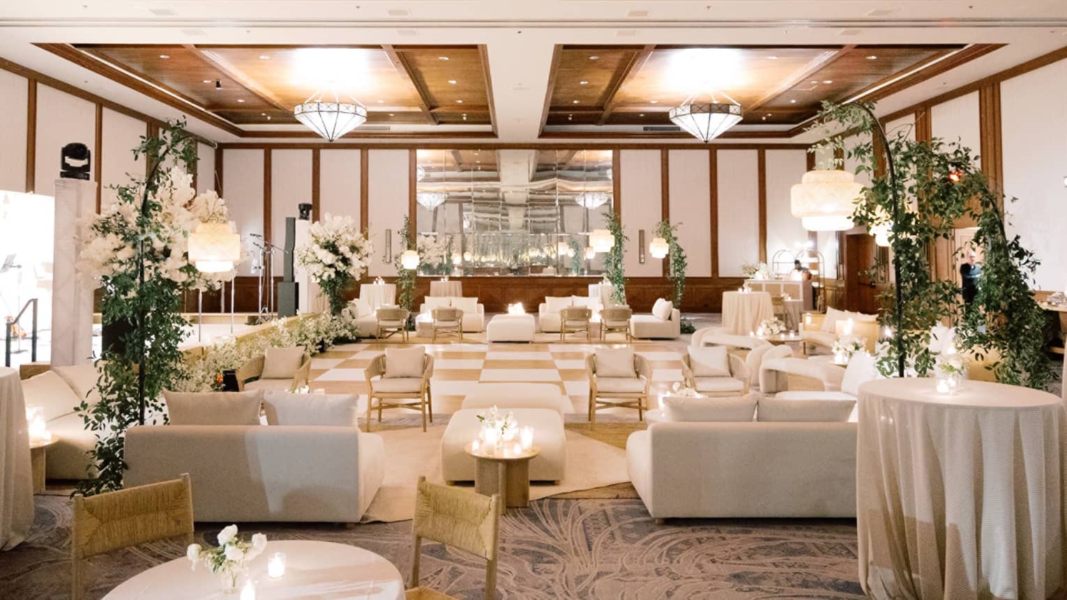 A wedding venue with couches and chairs and flower bouquets on the tables