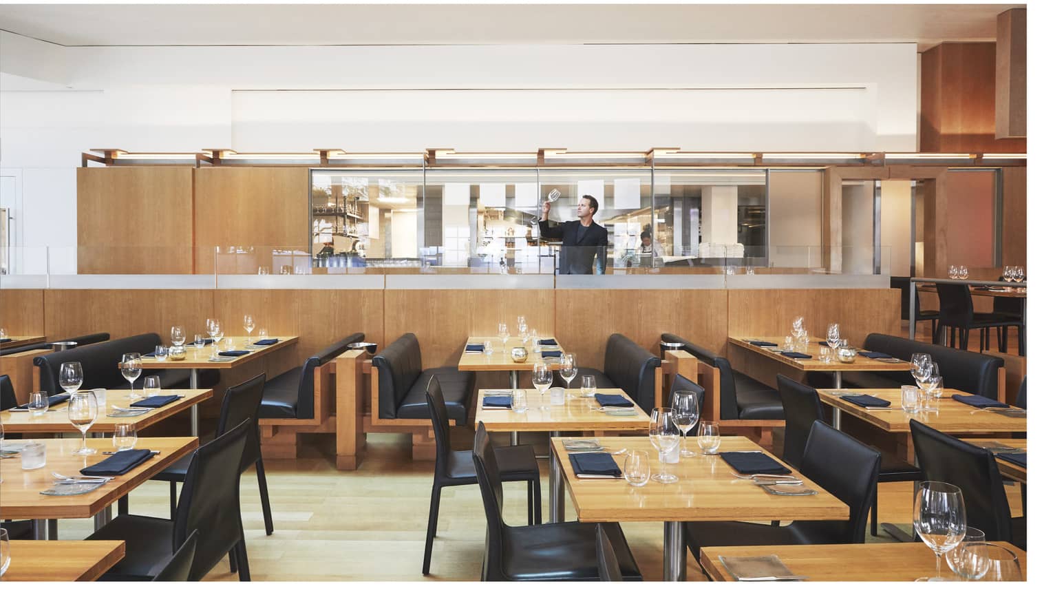 A dining area with wooden tables and black chairs.