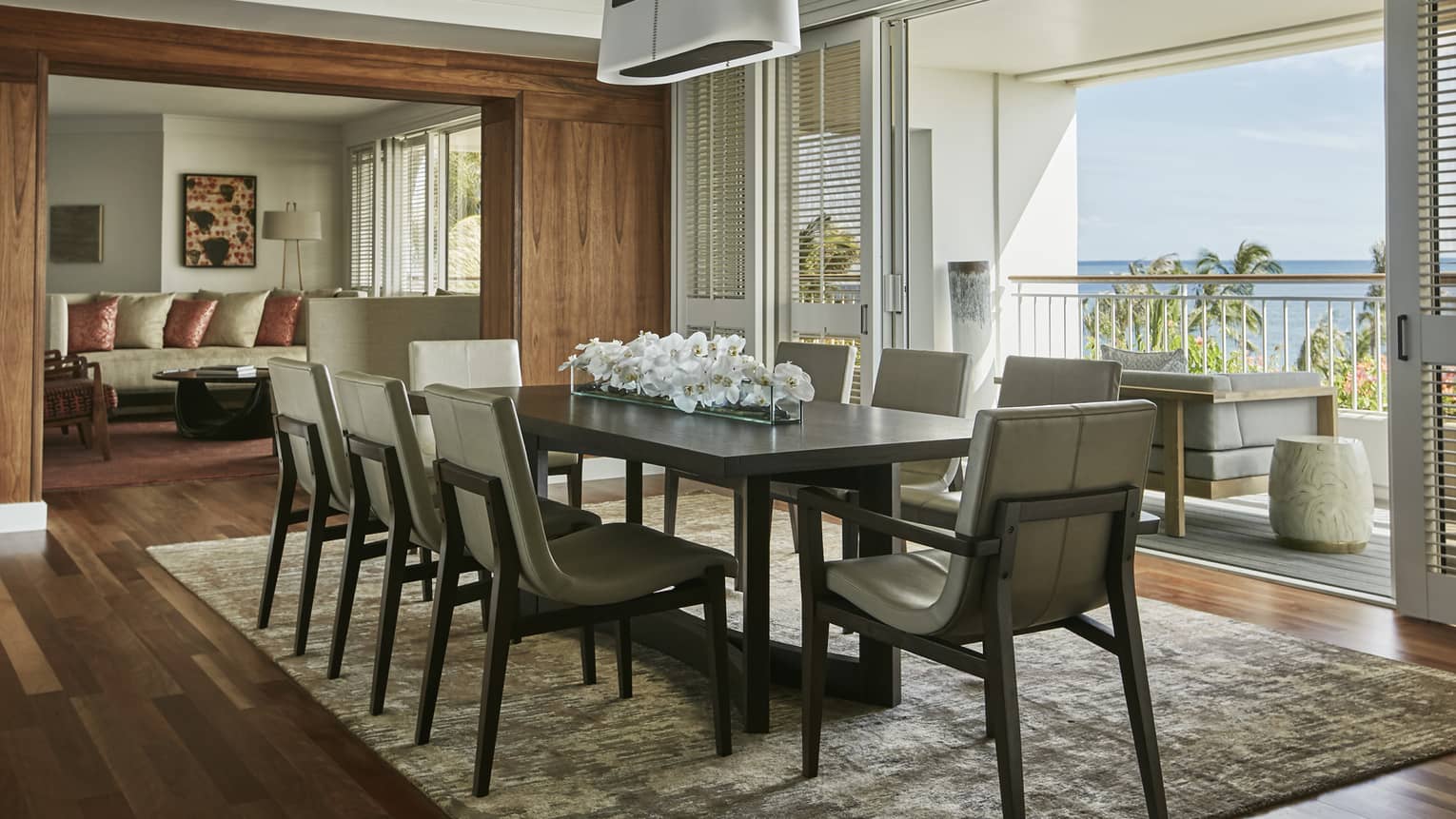 Presidential Suite long dining table with modern chairs, chandeliers, white floral centrepiece