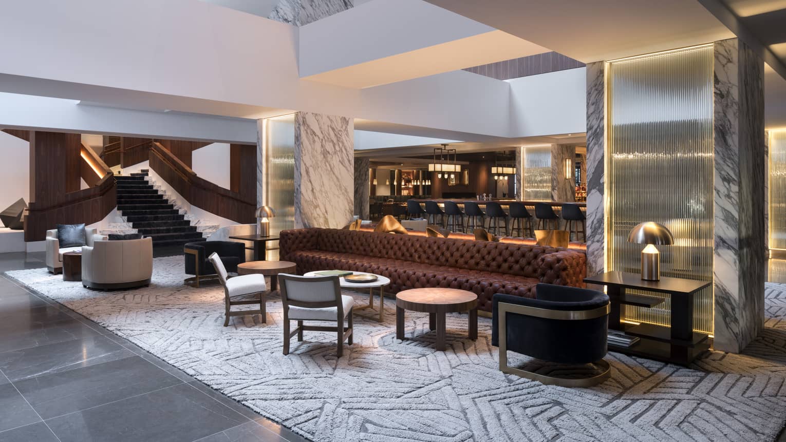 A lounge area with a bar, chairs and small tables.