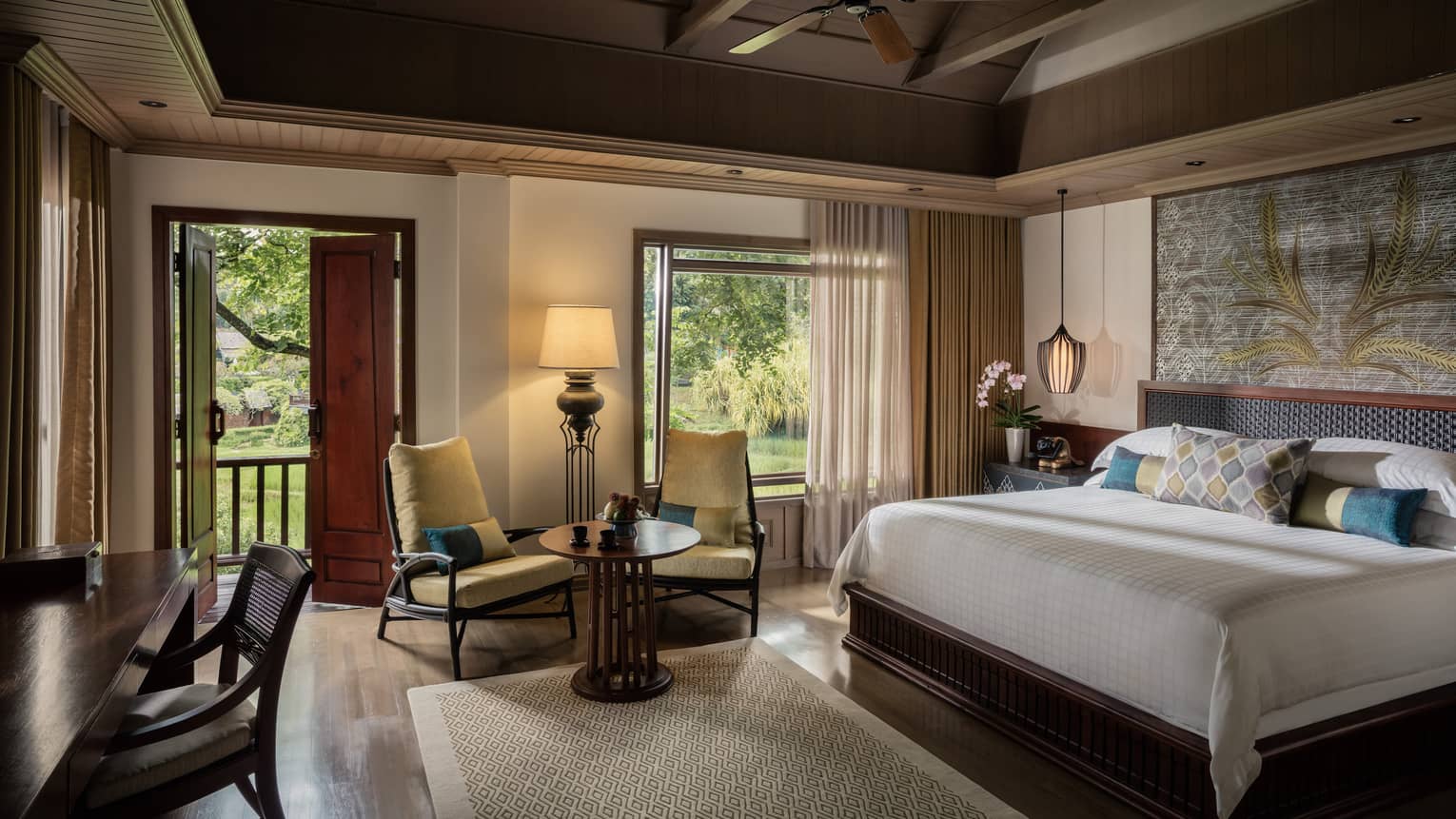 Upper Rice Terrace Pavilion Room bed, two yellow armchairs by sunny window, open patio door