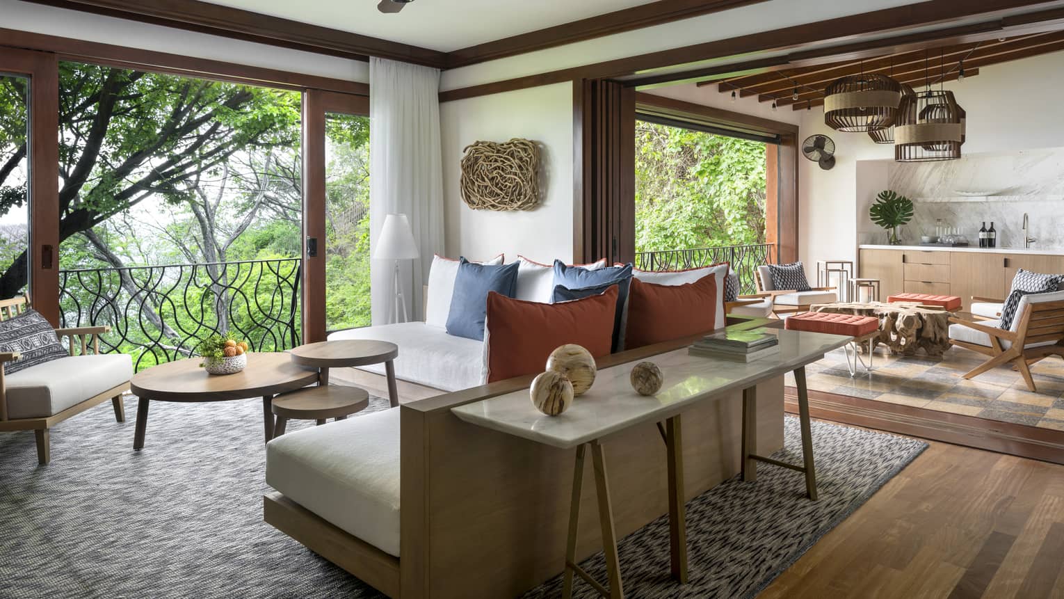 Pacifico Three-Bedroom Resort Residence airy living room, back of L-shaped sofa with wood frame, table with marble spheres