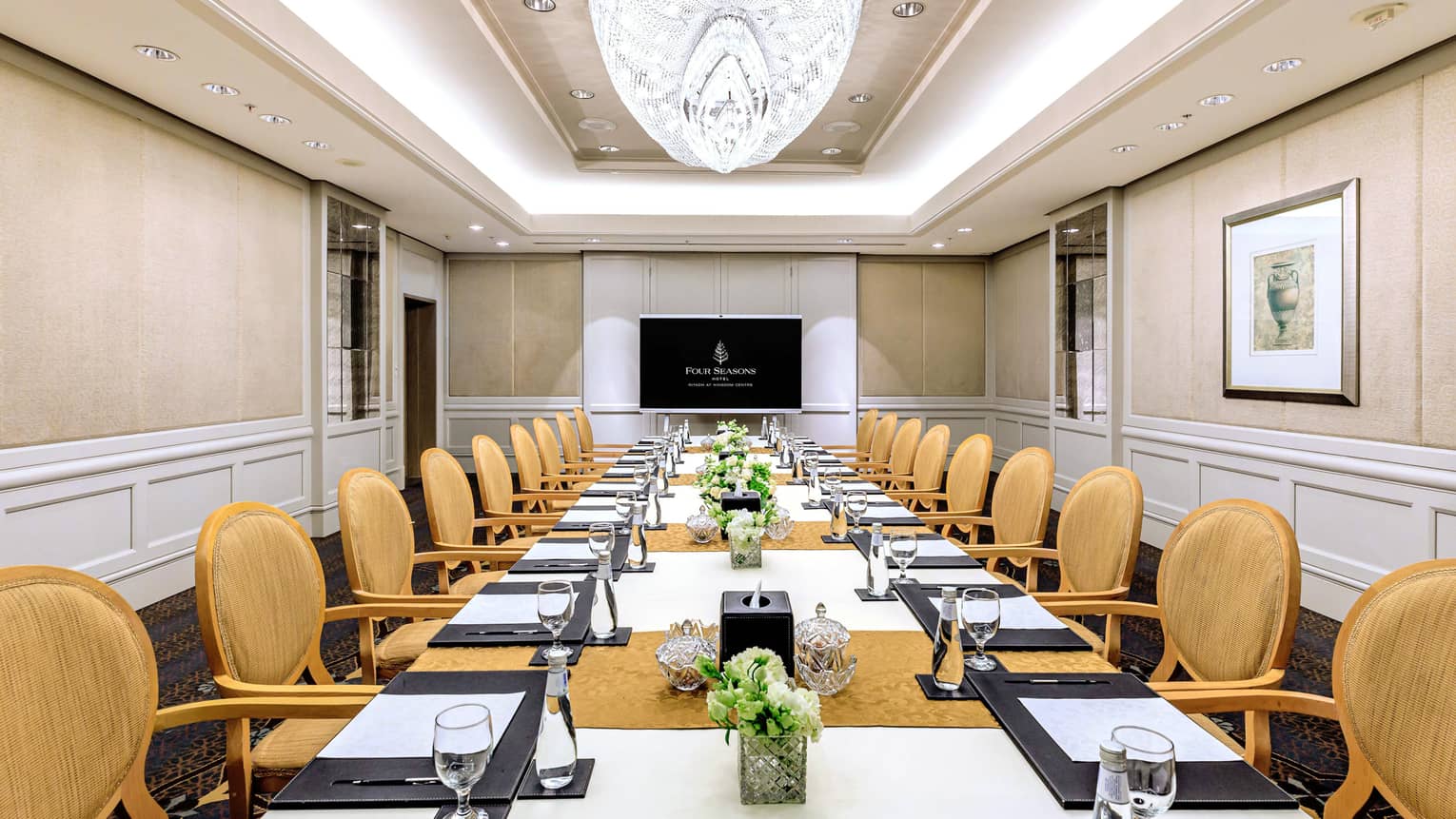 Elegant meeting room with crystal chandelier and board room seating