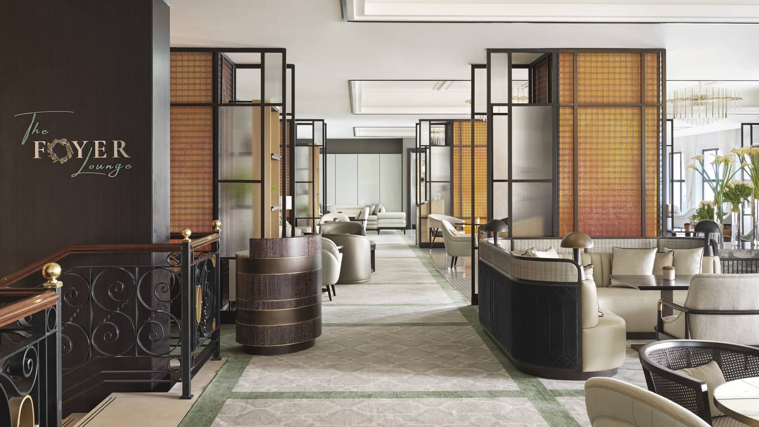 A view of the entrance to the Foyer Lounge complete with a black staircase, and several tables. 
