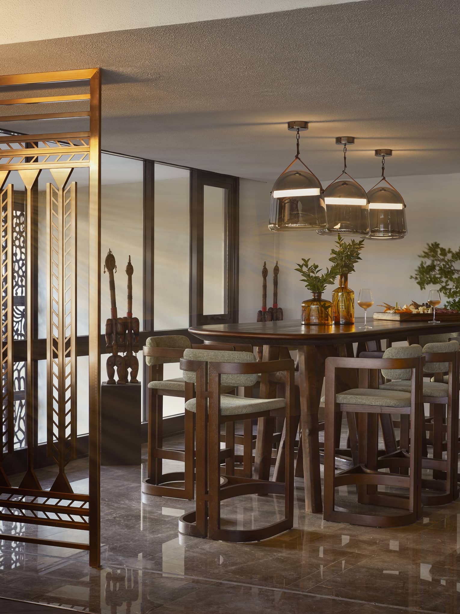 Restaurant with high-top oval table seating under three pendant lights
