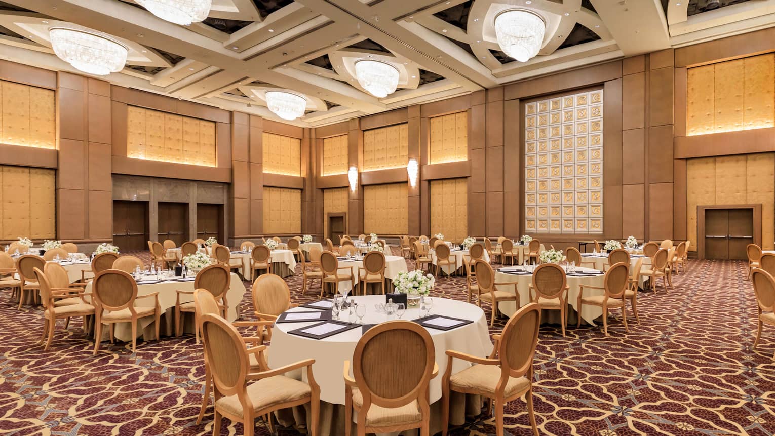 Banquet tables set for an event in a grand hotel ballroom