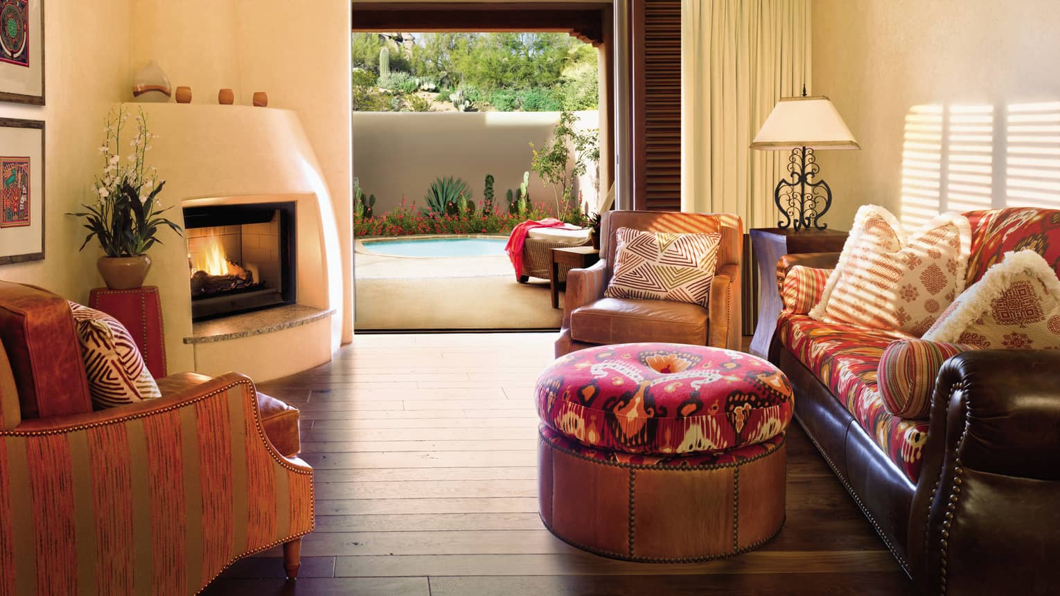 Kiva One-Bedroom Suite leather sofa, armchairs, stools with southwestern patterns, gas fireplace, patio to pool