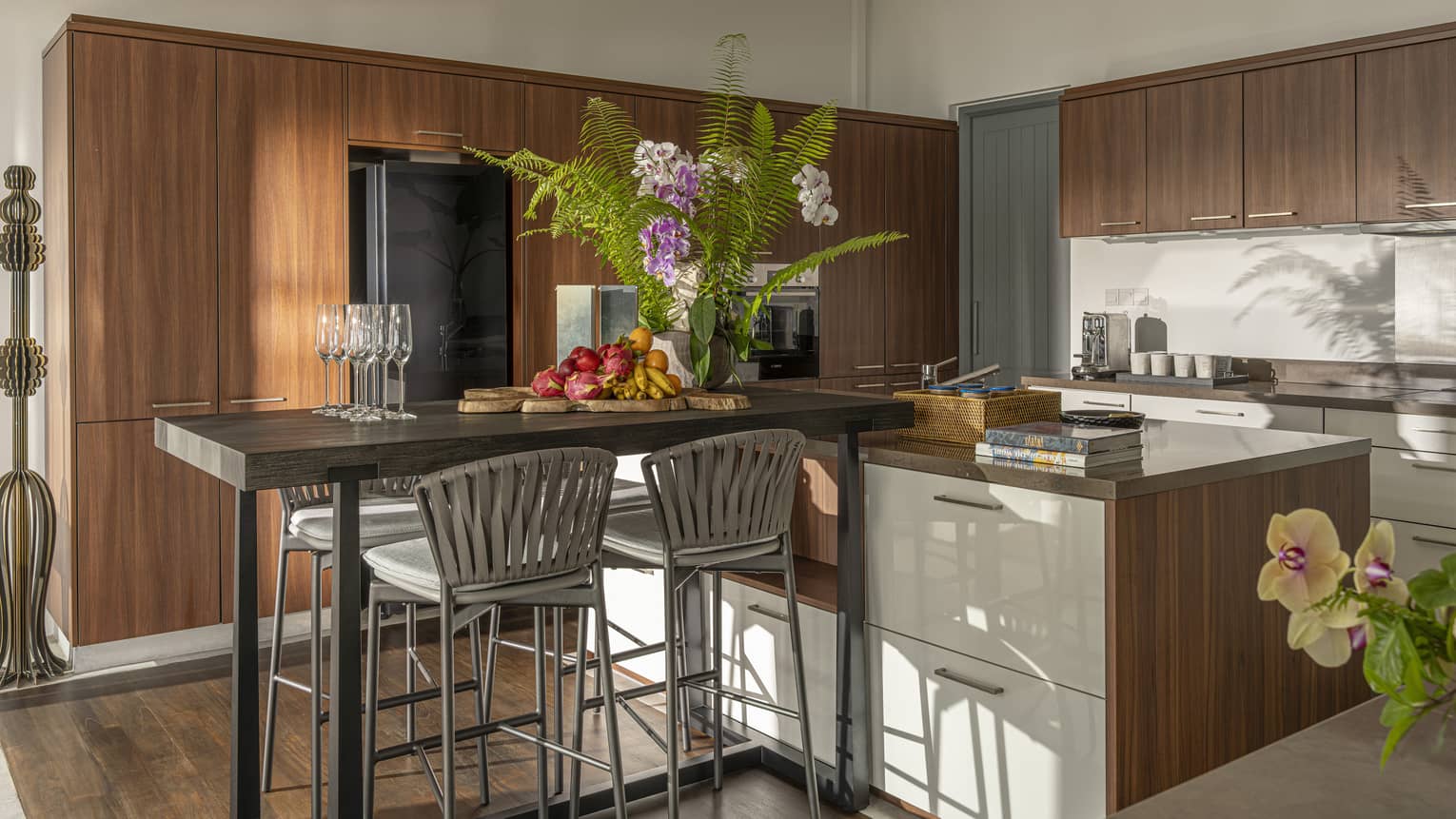 A gourmet kitchen featuring modern wooden cabinets and a high-top table with four chairs