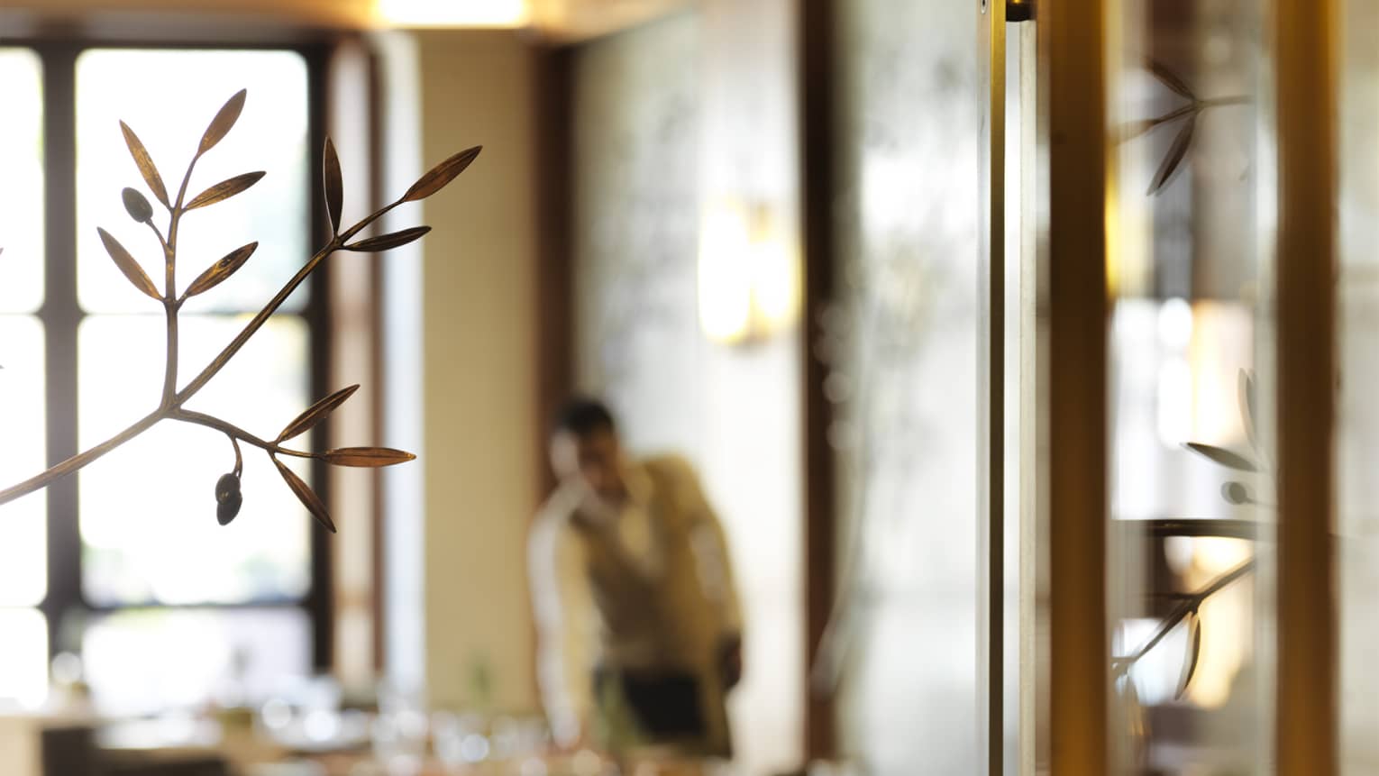 An out of focus image of a waiter serving a meal.