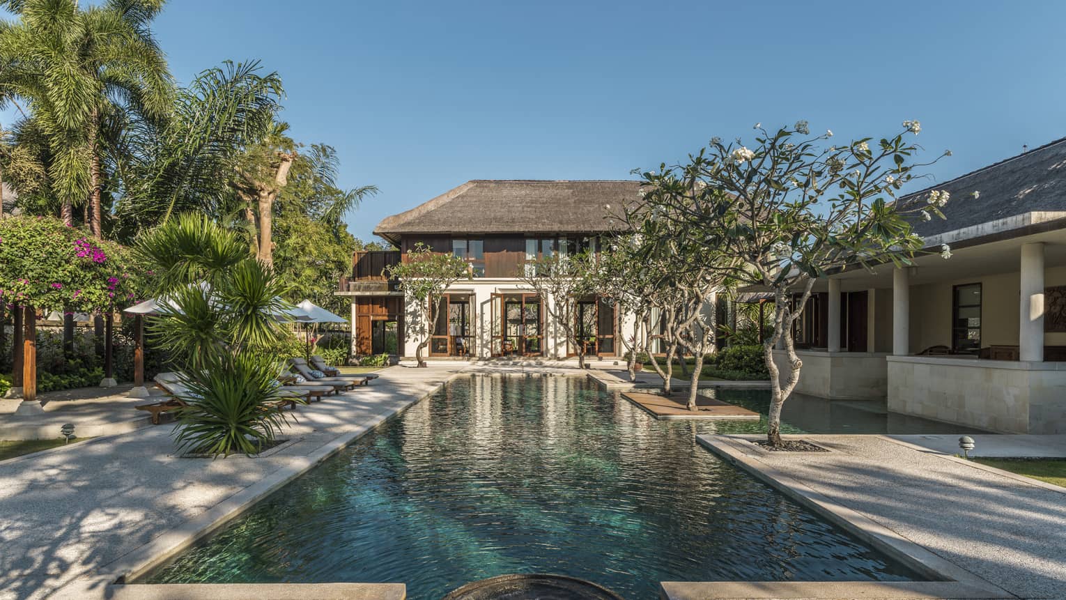 Turquoise water in long outdoor swimming pool leading to Residence