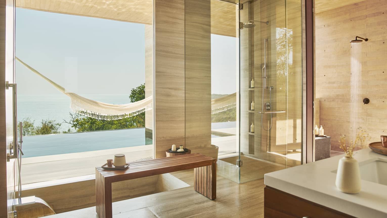 Indoor-outdoor, modern bathroom with infinity pool and ocean view