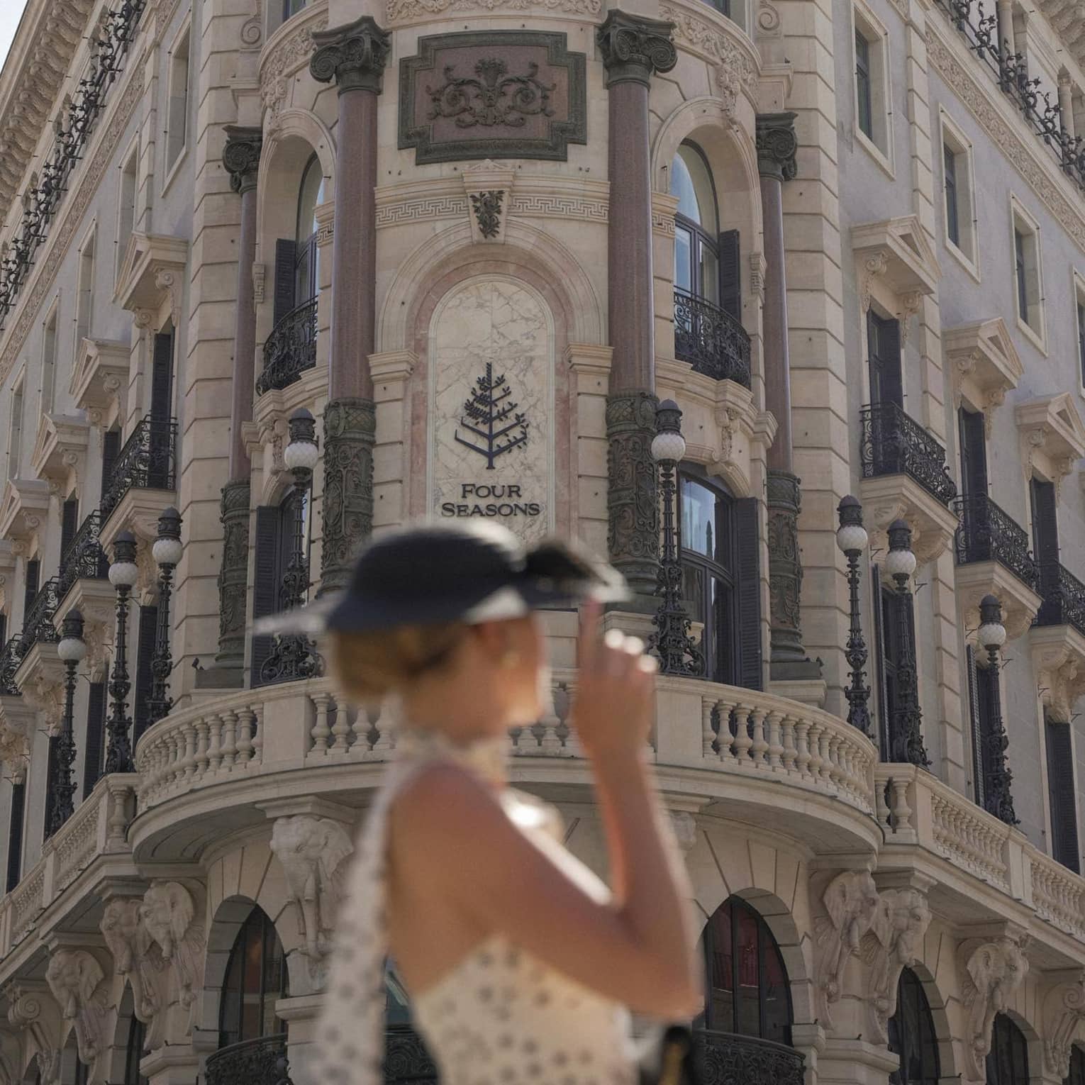 A woman looking toward the entrance of Four Seasons Hotel Madrid