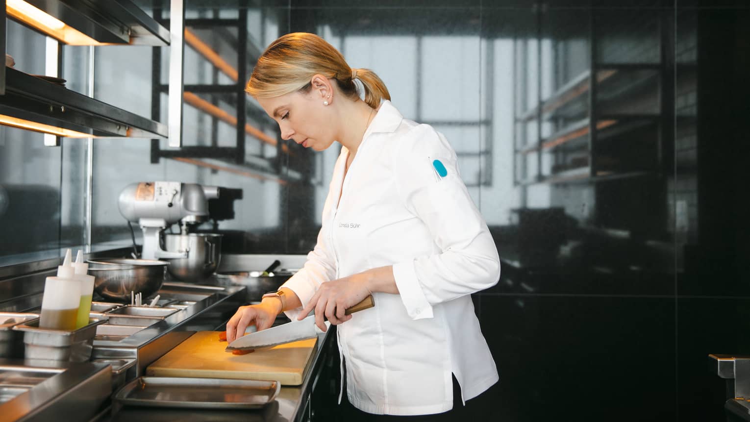 A chef using a knife in a kitchen.