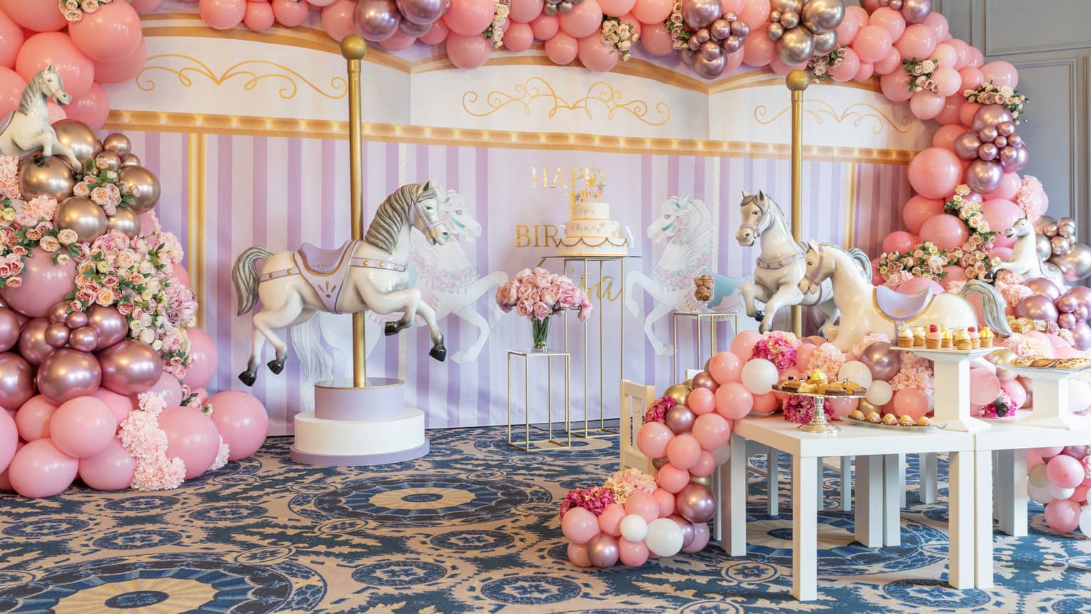 Pink carousel themed decorations fill an event space