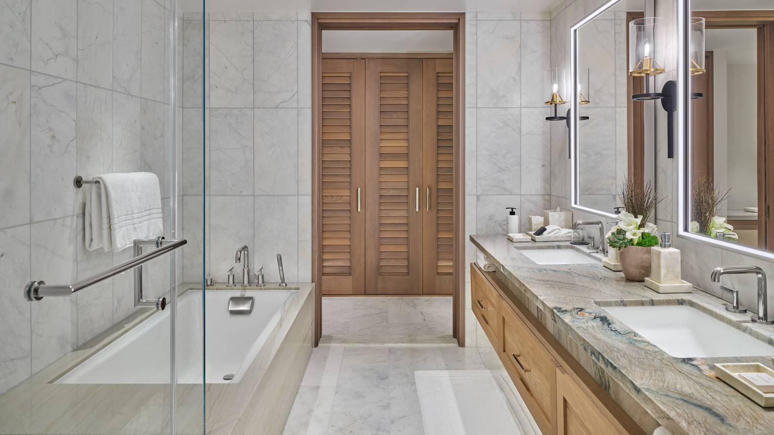 Marble bathroom with double vanity and tub