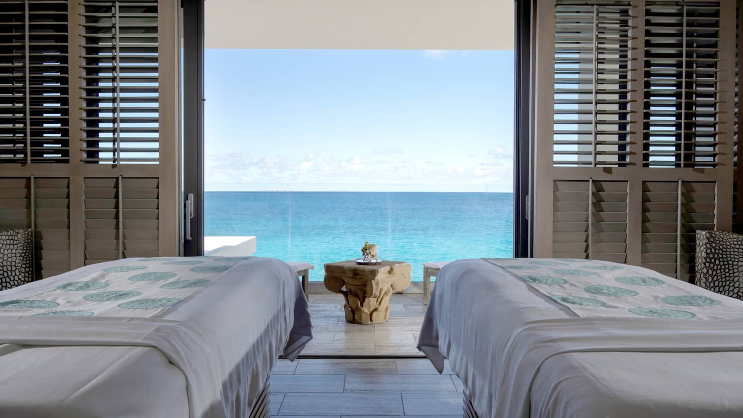 Couples massage beds in private spa cabana looking out at the ocean