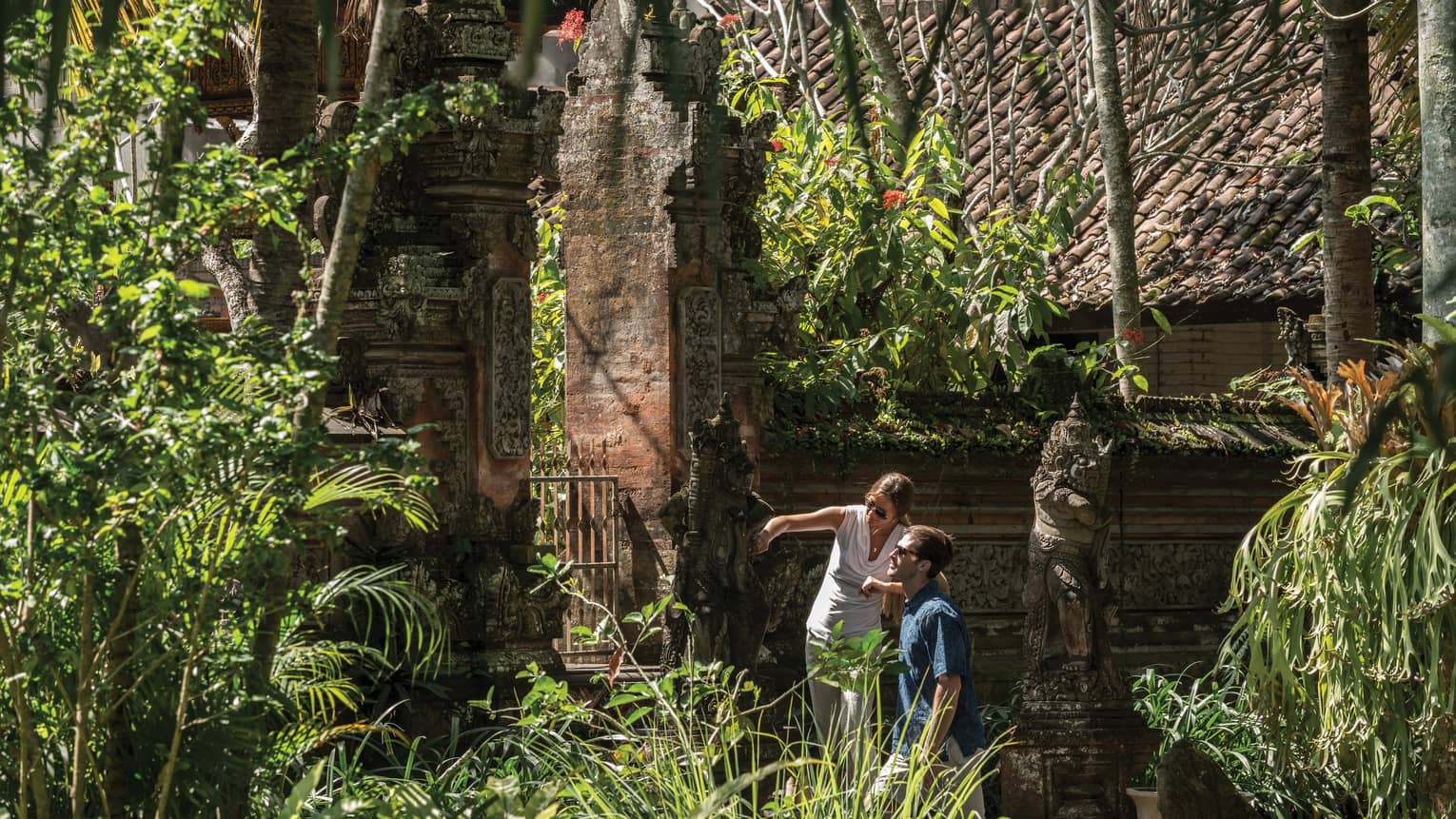 Gusts exploring decorative statues surrounding a temple in Bali