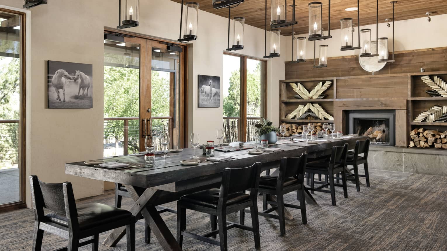 Dining room with hanging lights, a fireplace, a rectangular table and chairs.