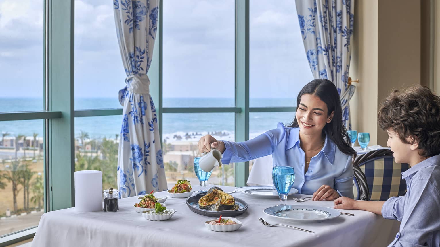 Mother and son enjoy fine dining at Kala Restaurant with views of the Mediterranean Sea
