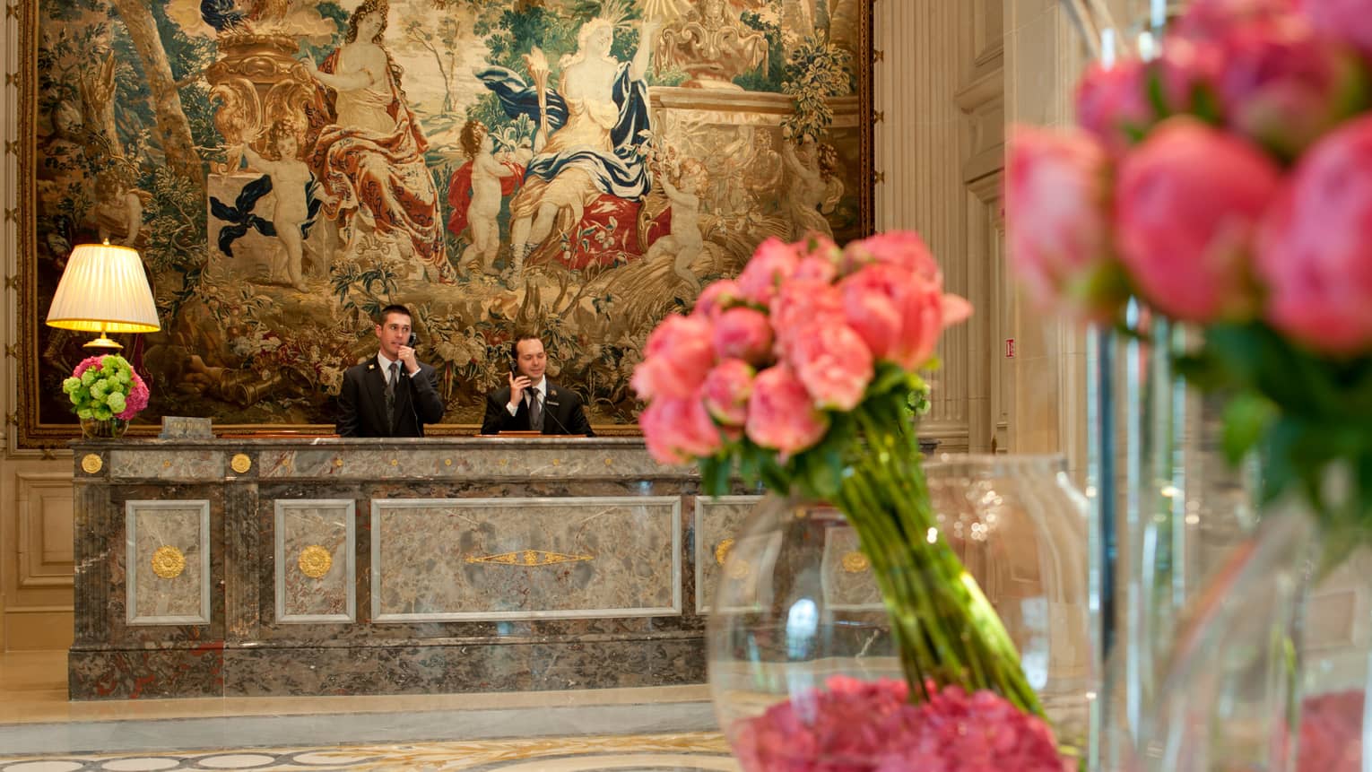 5 Star Hotel In Paris Luxury Four Seasons George V Hotel Staff Answer Telephones At Marble Reception Desk Under Large Mural Past Pink Flowers