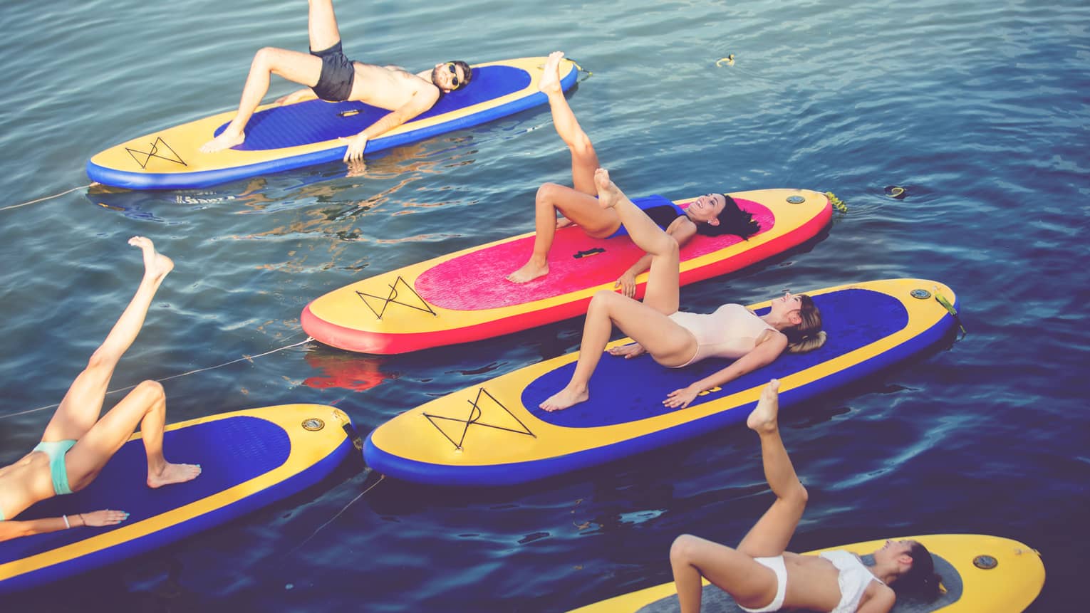 People float on paddleboards, stretch legs during FloYo fitness class
