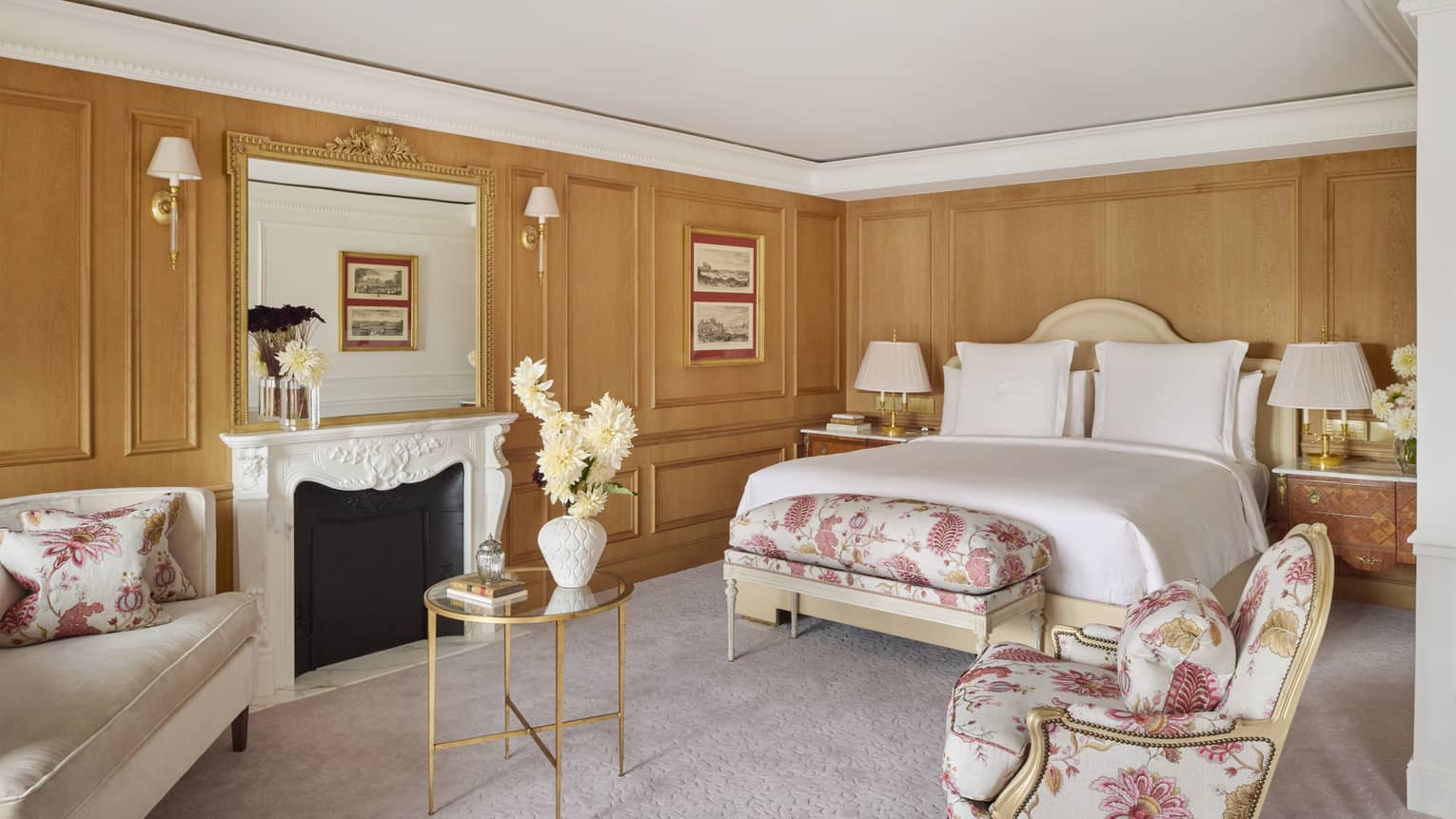 Elegant French bedroom with wood panelled walls, upholstered arm chair and bench