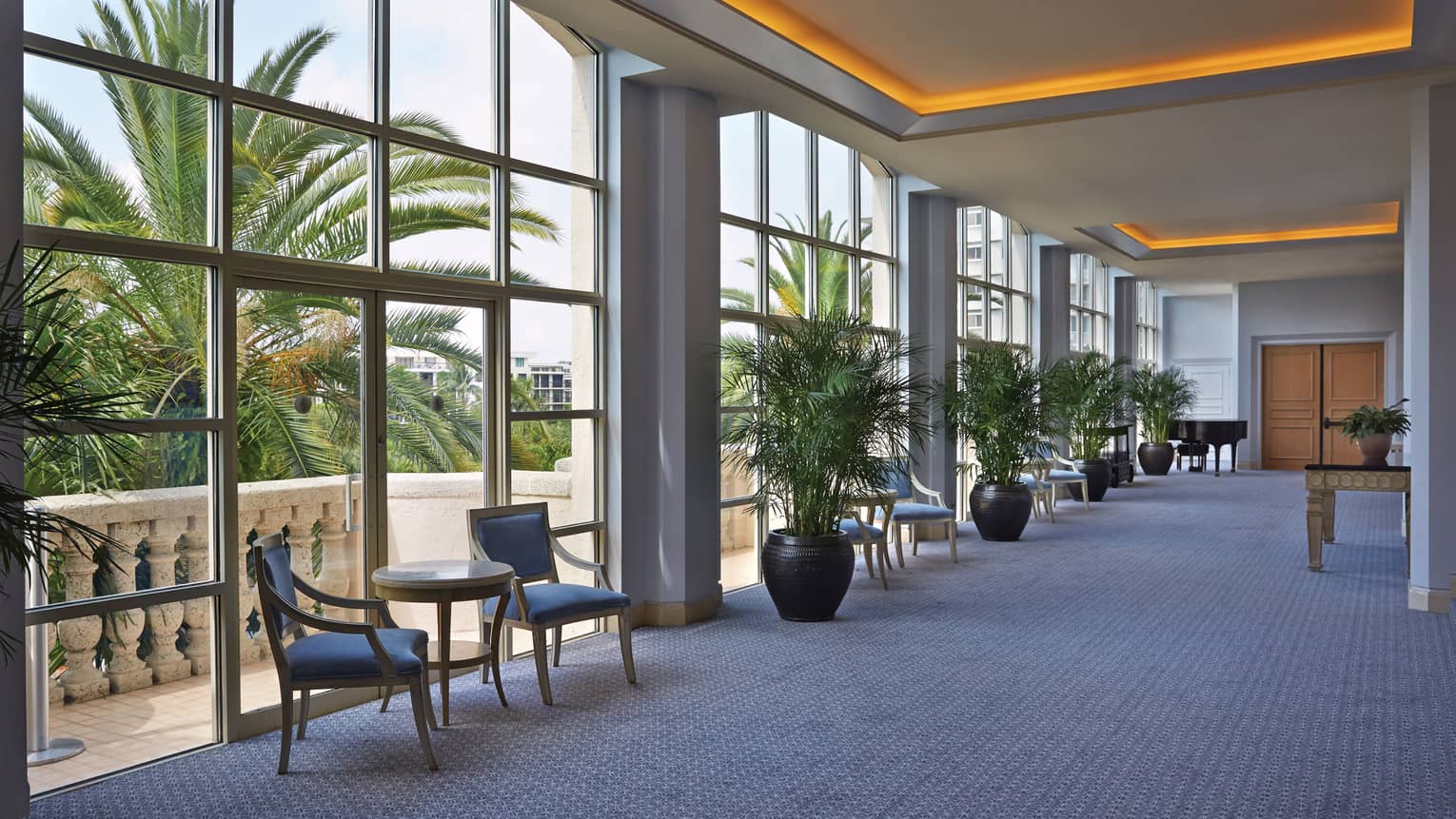 Royal Poinciana ballroom foyer with floor-to-ceiling loft windows, orange lights along ceiling
