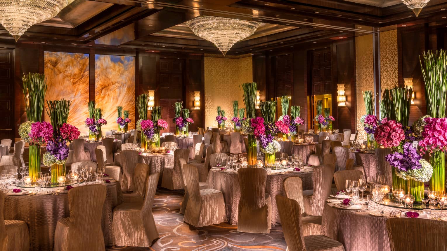 Imperial Ballroom wedding reception with fabric-covered chairs, floral centrepieces, crystal chandeliers