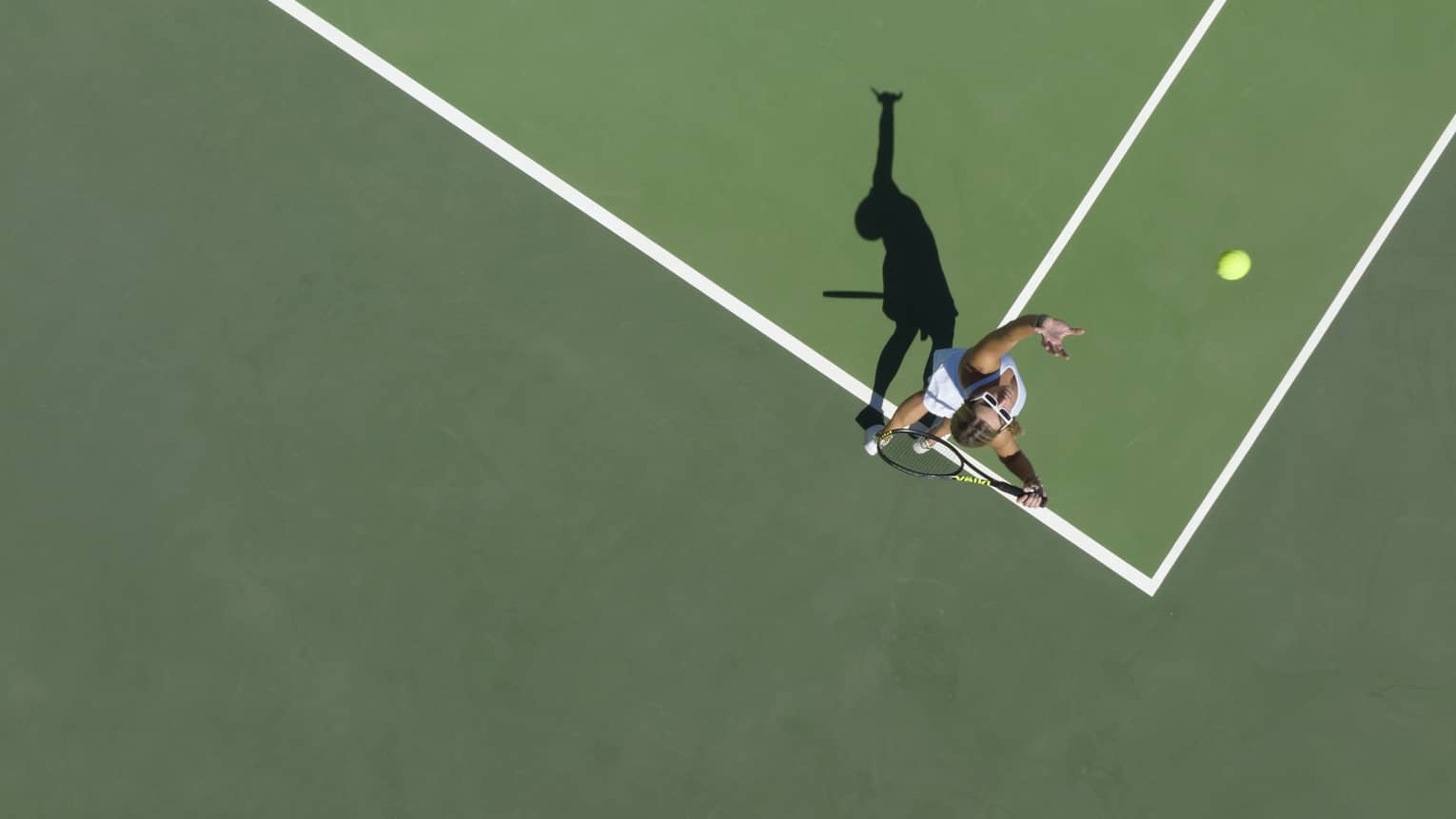 Aerial view of a tennis player mid serve