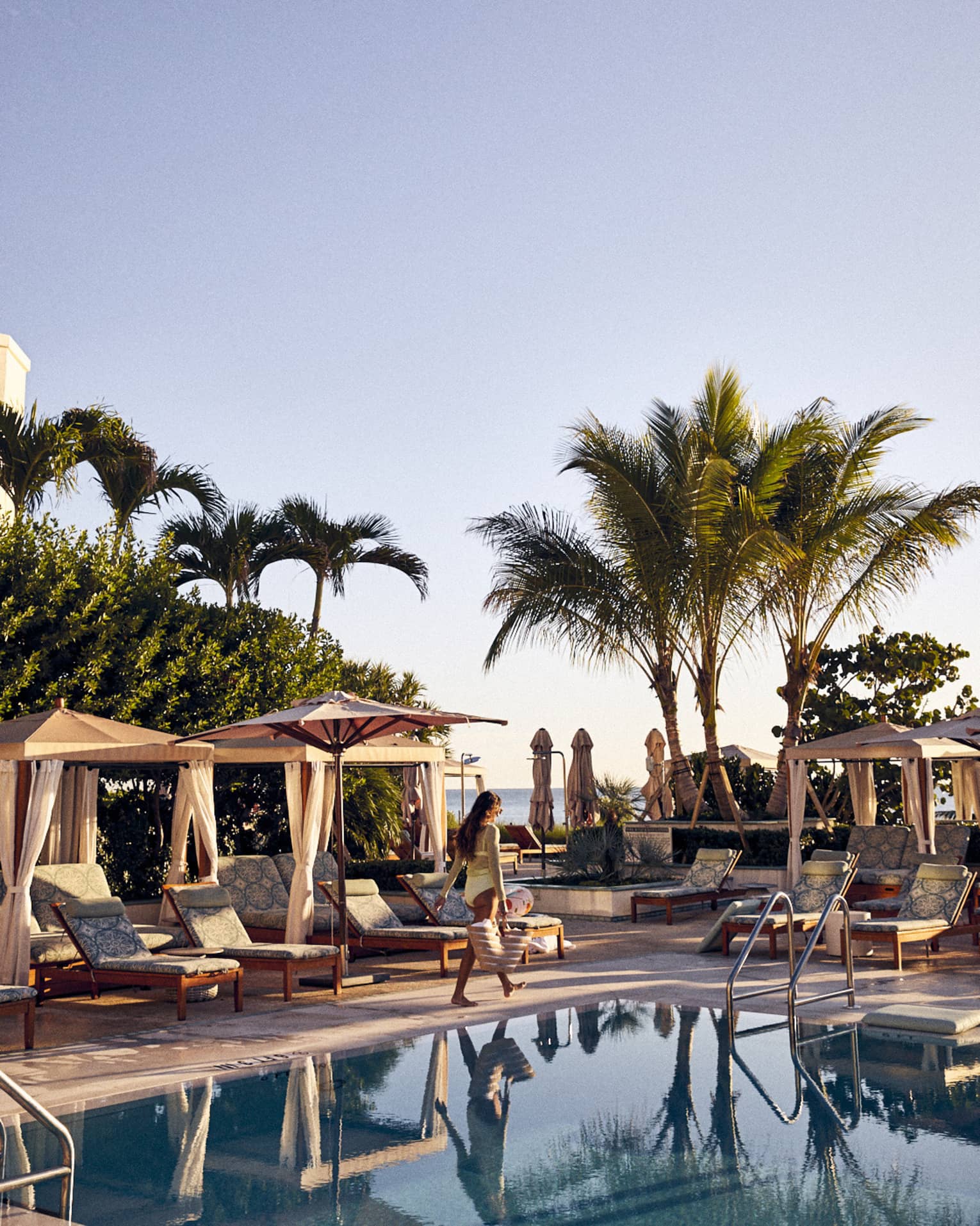 Guest walks by a row of poolside cabanas