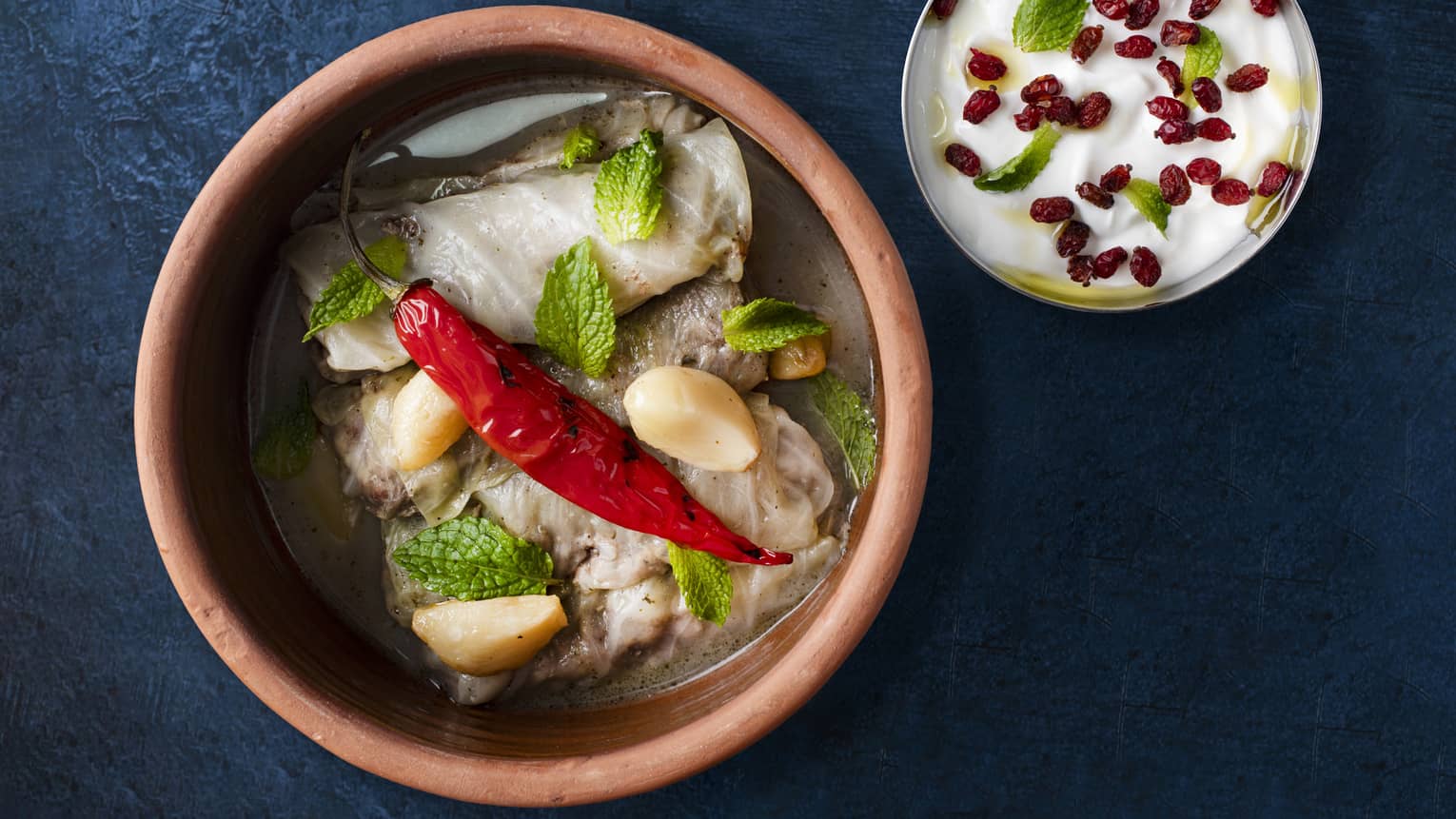 Cabbage leaves stuffed with rice and minced lamb, served with citrus broth, mint and yogurt dip