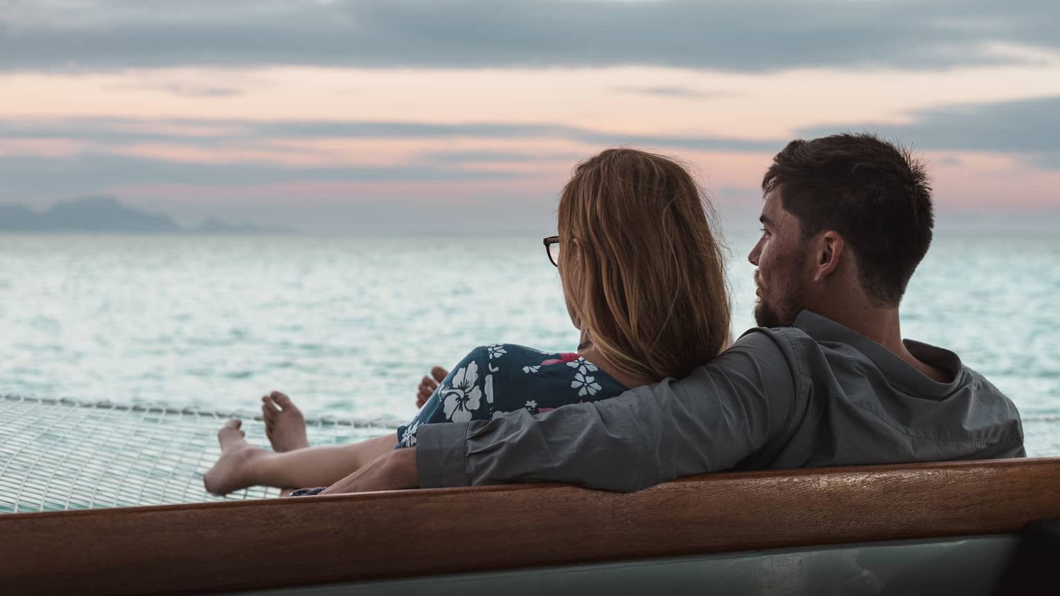 Couple sits side by side at sea