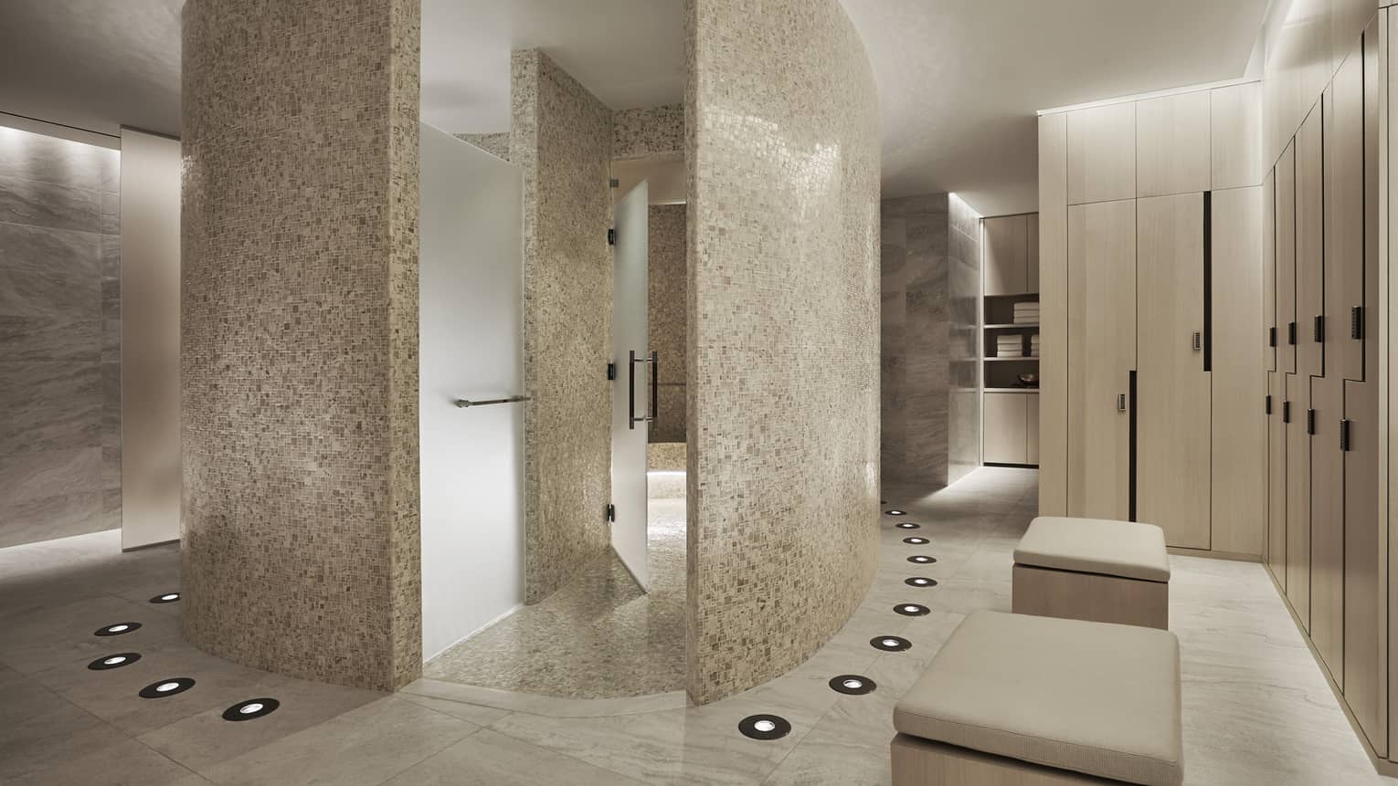 Curved white stone walls in Spa locker room, wood lockers 