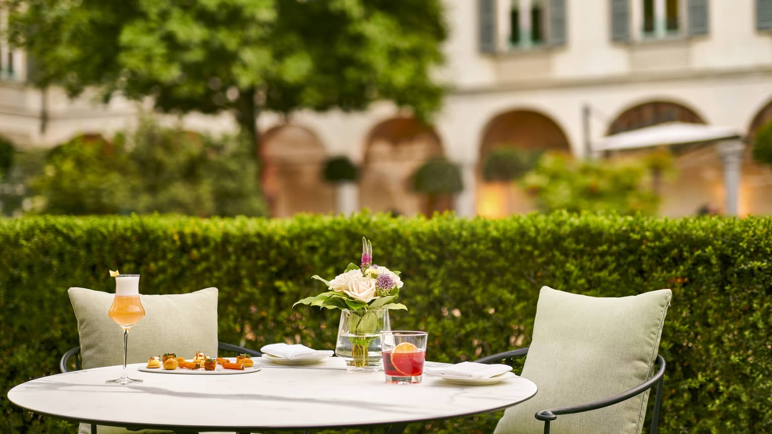 Milanese aperitivo, cocktails on small garden patio table