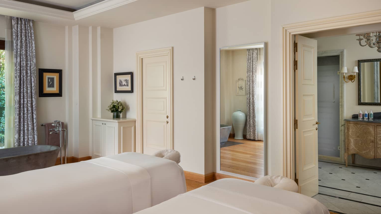 A light and spacious spa treatment room with two treatment tables side by side