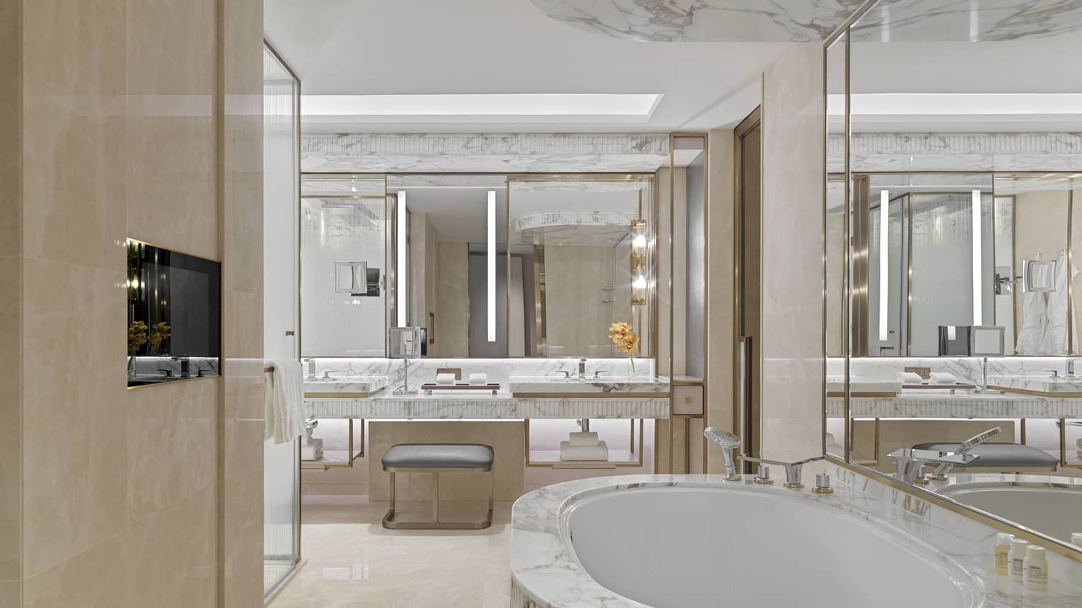 Grand bathroom with deep soaking marble bath tub and marble vanity
