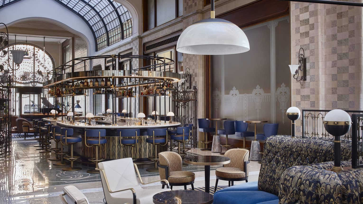 Modern white or brown leather chair pairs, blue banquettes in bar lounge, bar in backdrop