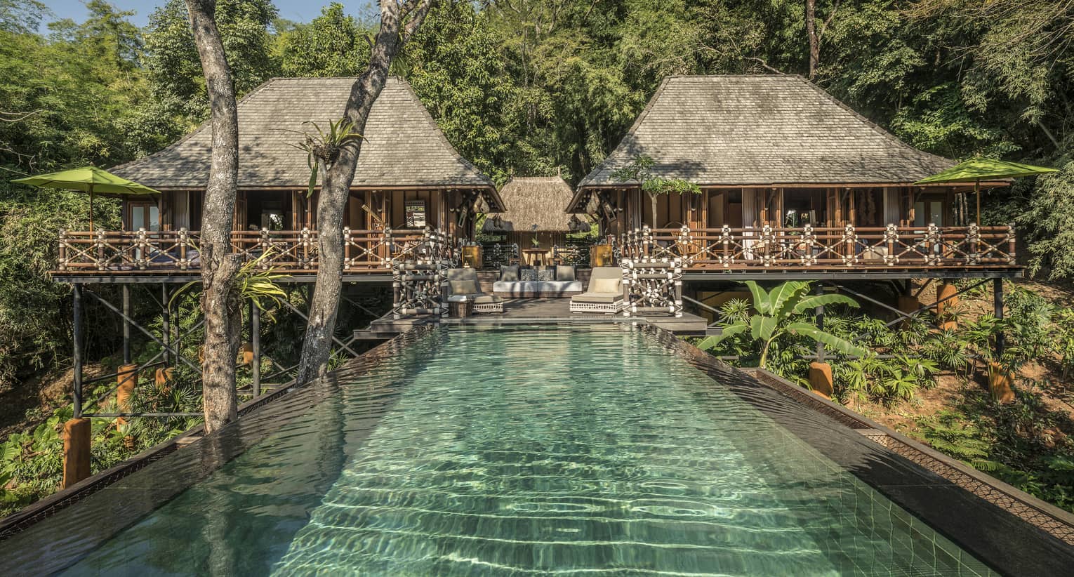 Two-bedroom Explorer's Lodge bungalows with small patio in middle leading to long swimming pool