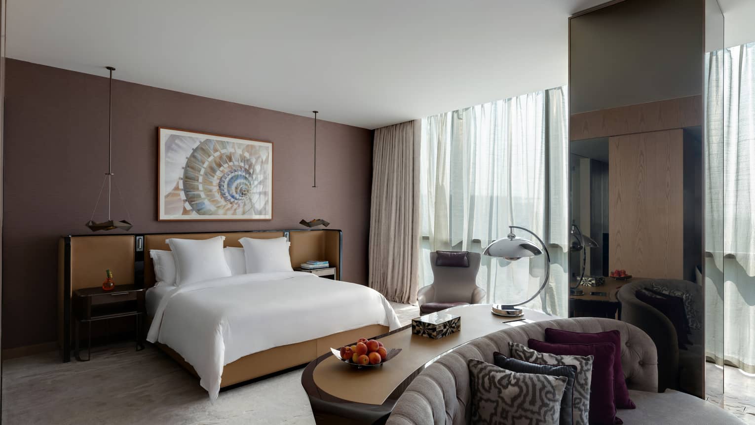 Bedroom with brown wall, windows, king bed and sitting area