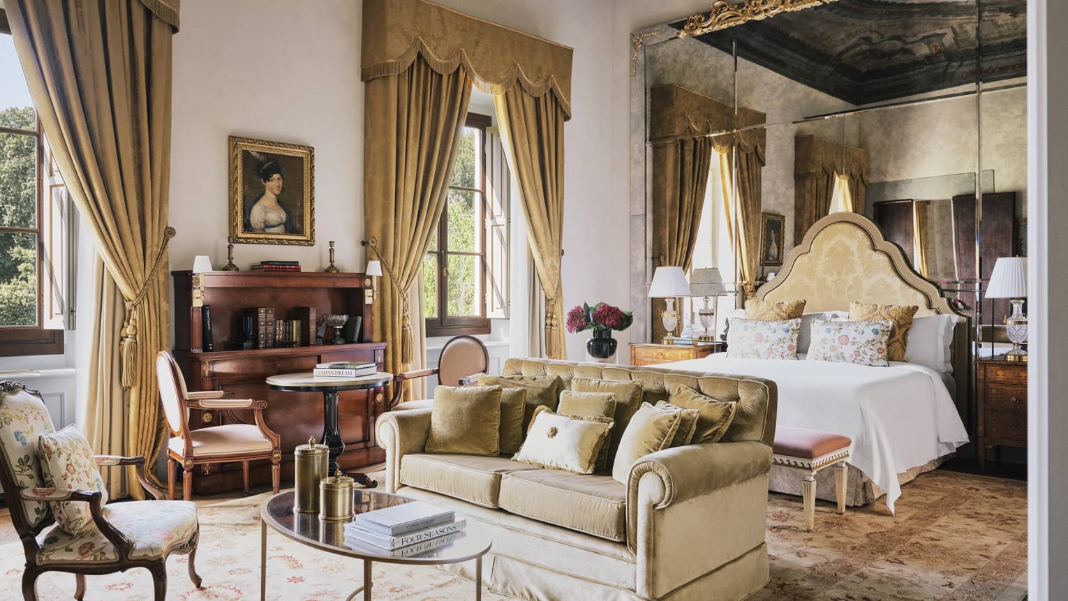 Renaissance Suite bedroom with a king bed, sitting area, elegant curtains and mirrored wall at Four Seasons Hotel Florence