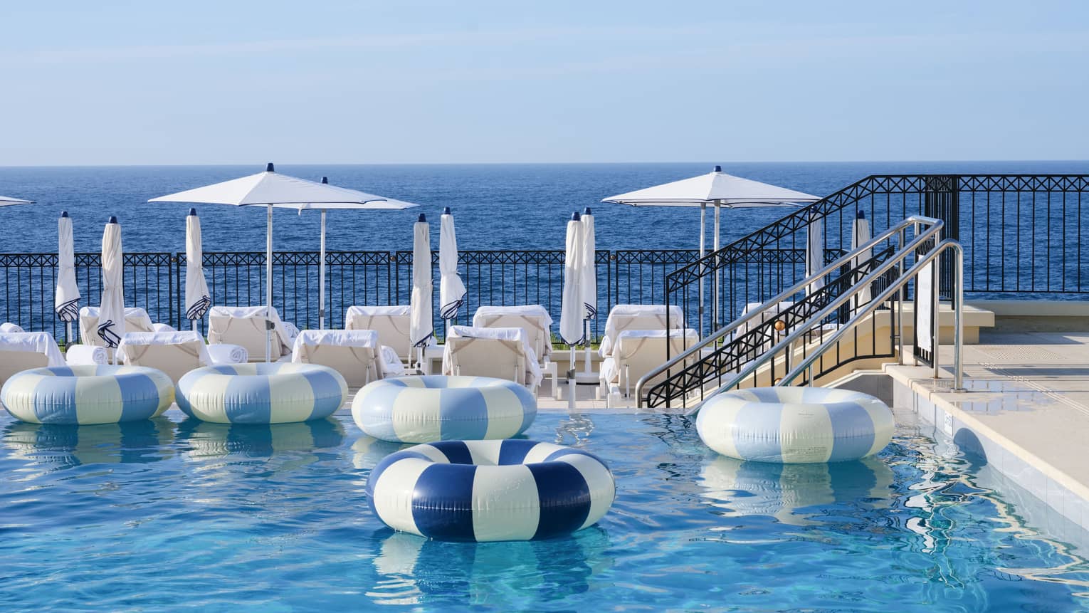Inflatable blue-striped inner tubes drifting in luxury hotel pool