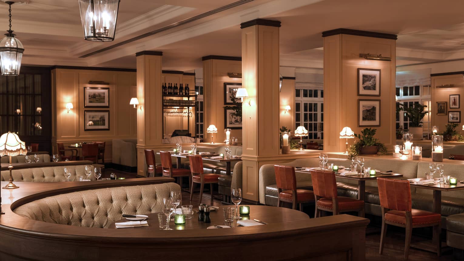 Large curved booths behind tables, chairs in dimly lit dining room