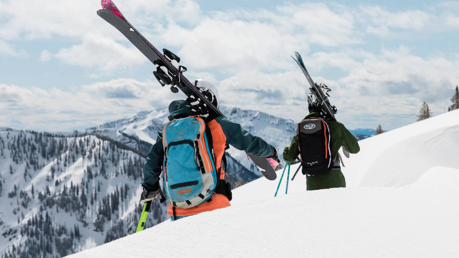 Two people in ski gear walking along a ski trail