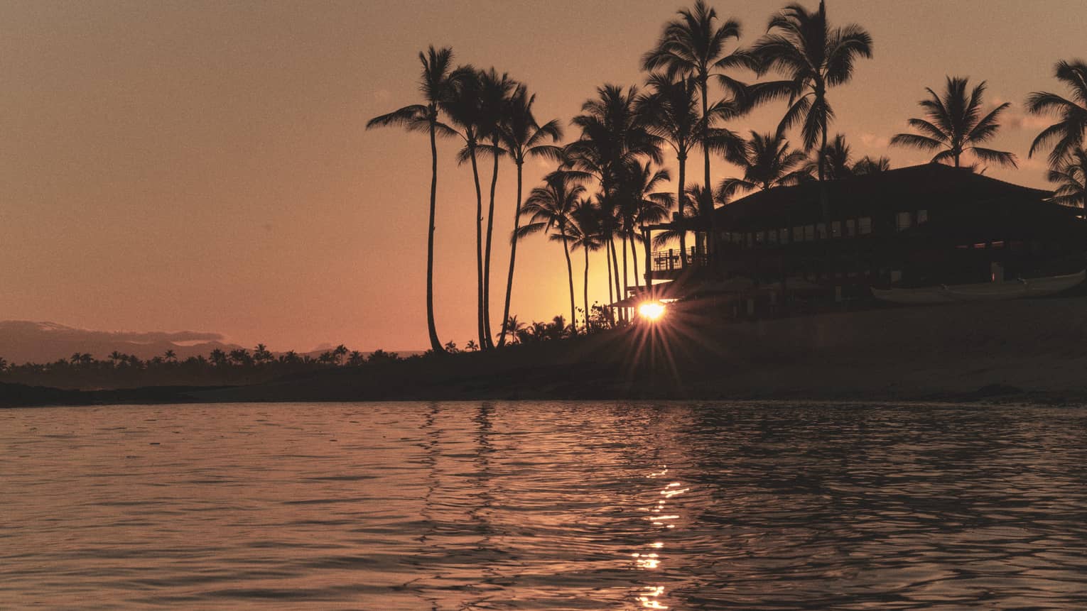 Tropical resort on the water at sunset