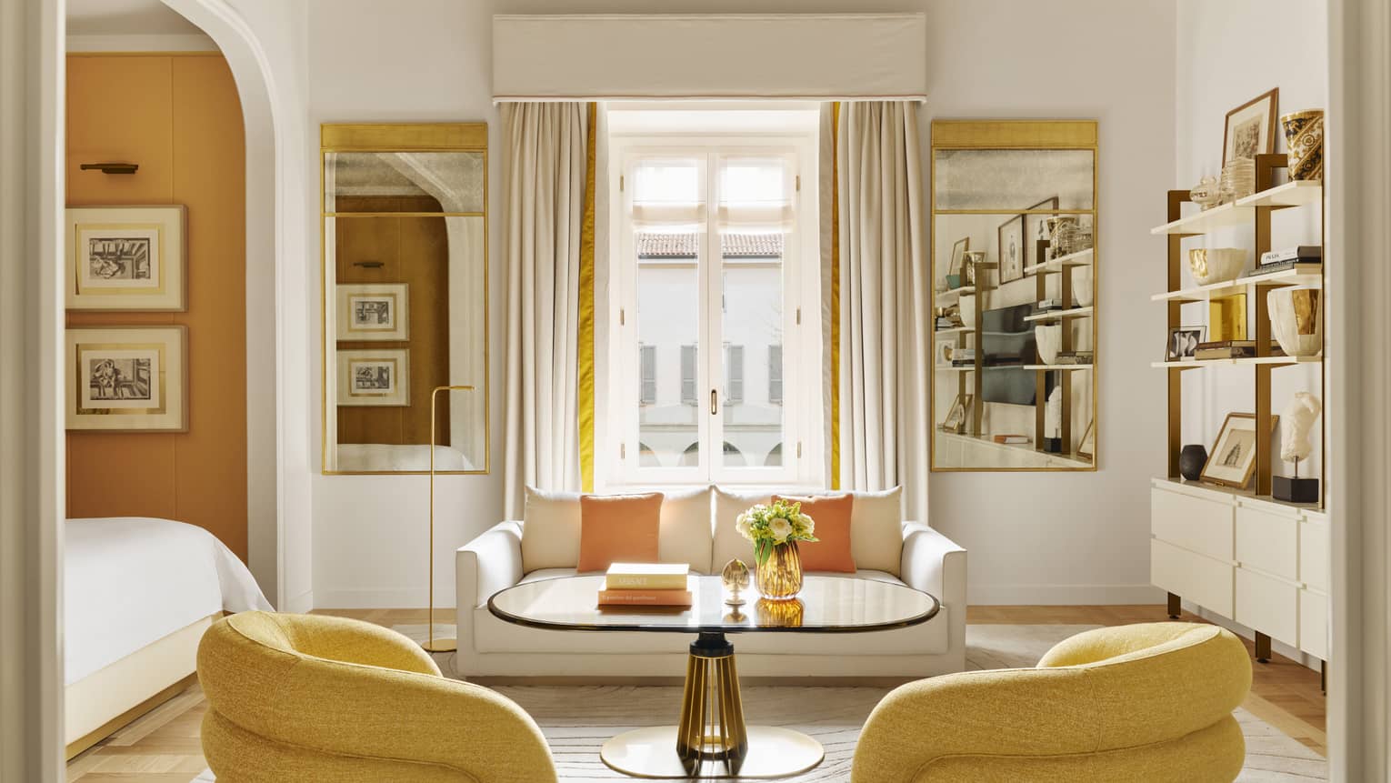 Luxury hotel suite with frescoed ceiling and modern yellow arm chairs, white sofa and adjacent bedroom