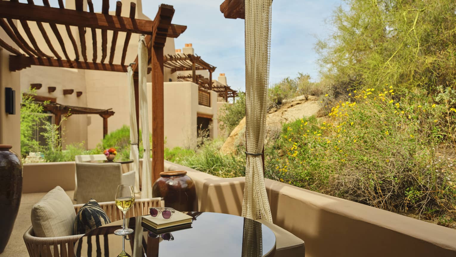 A table and two chairs on a private terrace with pergola